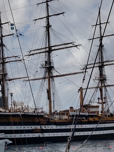 Die Masten und die Takelage des Segelschulschiffs Amerigo Vespucci mit seinem schwarz-weiß gestreiften Rumpf im Hafen von Triest