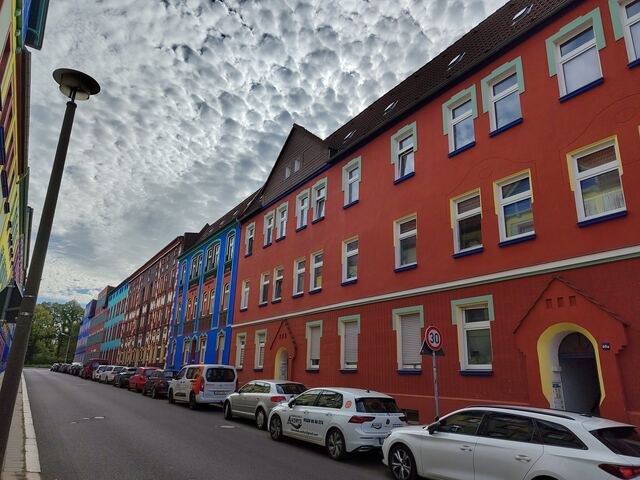 Rote Hausfassaden mit mintfarbenen Fenstereinfassungen
