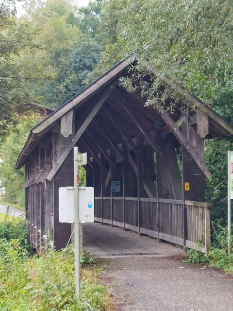 Radweg durch eine überdachte Holzbrücke